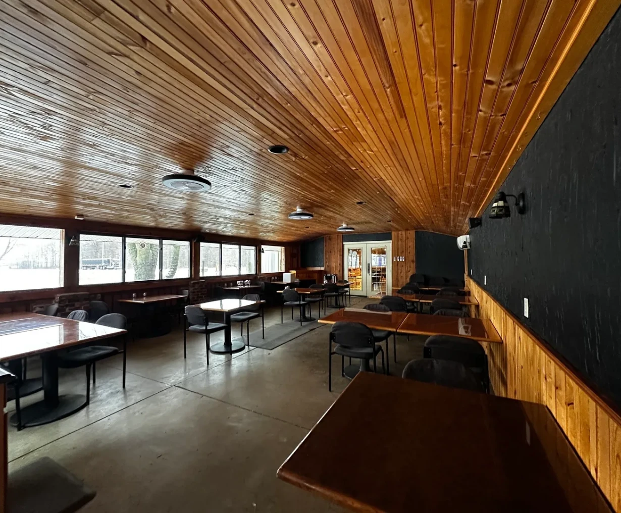 Empty restaurant interior with wooden ceiling.